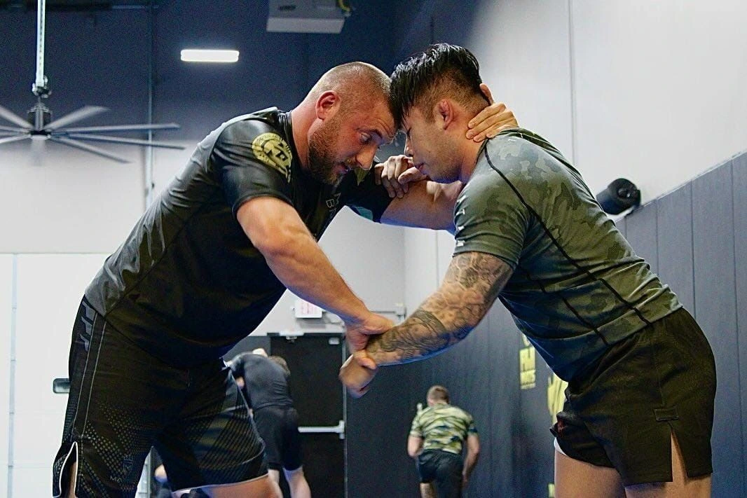 Two Mooresville Brazilian Jiu-Jitsu adults in a clinch at training — what a real class looks like